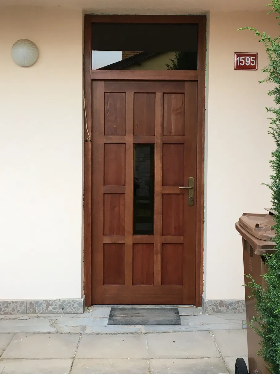 tmavé dřevěné vchodové dveře s prosklenou částí uprostřed