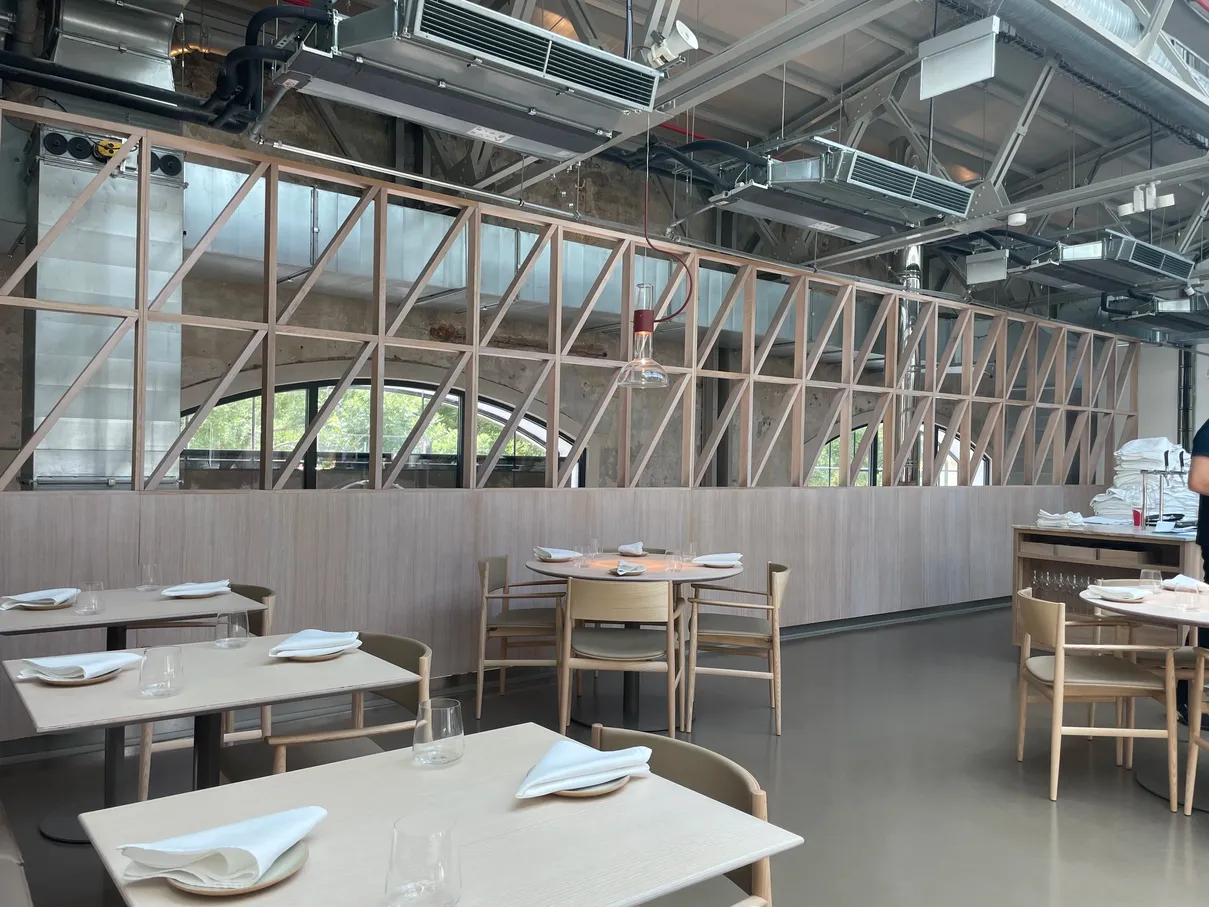 pohled při sezení v restauraci na dřevěnou atypickou zeď s vyřezanými průhledy